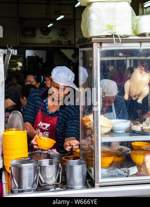 IPOH, MALAYSIA - Dezember 11: Mann serviert Hühnersuppe für Clients in einem Food Court von Ipoh am 11 Dezember, 2018 in Ipoh, Malaysia. Stockfoto
