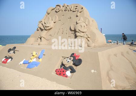 Ein Sand Skulptur von Zeichen aus der Amerikanischen animierte TV-Serie und Film 'Mickey Mouse' wird auf dem Display auf einem Strand in Rizhao,'s East China Shandong Stockfoto