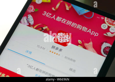 ---- Eine chinesische Mobiltelefon Benutzer schaut auf ein Logo des mobile App der Chinesischen e-commerce Plattform Pinduoduo auf seinem Smartphone in Ji'nan Stadt, Ost Stockfoto