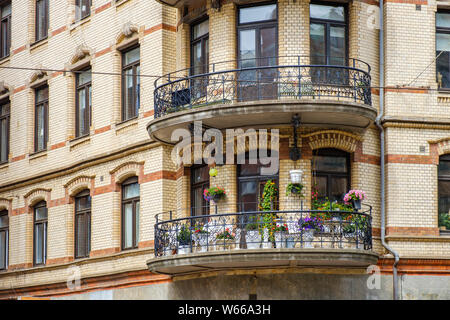 Balkon mit Blumen auf einem Wohngebäude Stockfoto