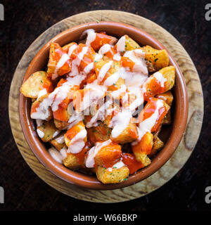 Spanische Kartoffeln Patatas Bravas für Tapas mit Tomaten und würziger Soße auf einer Schüssel Stockfoto