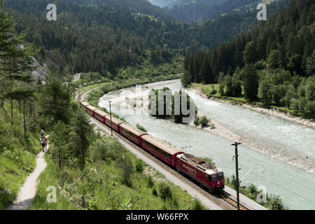 Versam, GR/Schweiz - 30. Juli 2019: Wanderer und der Rhätischen Bahn am Ufer des Rheins in der ruinaulta Schlucht in den Schweizer Alpen Stockfoto