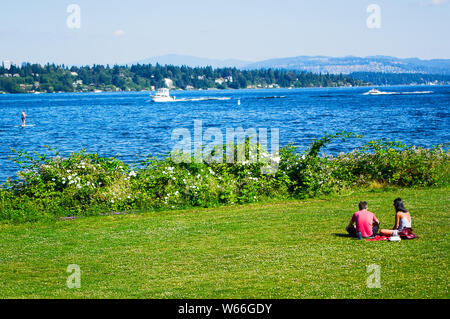 Ein paar bei einem Picknick im Park, am Rande des Lake Washington, Stockfoto
