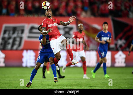 Brasilianische Fußballspieler Paulinho, oben, von Guangzhou Evergrande Taobao Köpfe die Kugel gegen den brasilianischen Fußball-Spieler Luiz Fernandinho von Chongqing Stockfoto