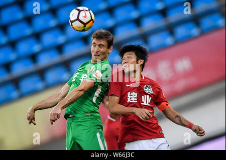 Kroatischer Fußballspieler Nikica Jelavic, links, von Guizhou Hengfeng leitet den Ball einem Spieler von Henan Jianye in der 14. Runde gegen während der Stockfoto