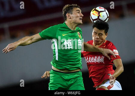 Kroatischer Fußballspieler Nikica Jelavic, links, von Guizhou Hengfeng leitet den Ball gegen einen Spieler von Guangzhou Evergrande Taobao in Ihren 12 ma Stockfoto
