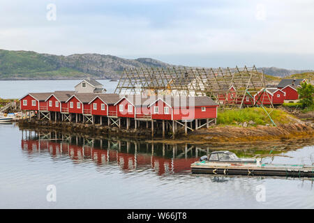 Typische Szene - Lofoten Rorbu, auf Land gebaut, aber mit einem Ende auf Pfählen im Wasser und Fisch Trockner für Kabeljau, Svolvaer, Austvågøya, Lofoten, Norwegen Stockfoto