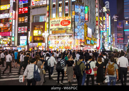 Menschen, die die Straße in Shinjuku, Godzilla Straße, Tokio, Japan, nachts überqueren. Stockfoto