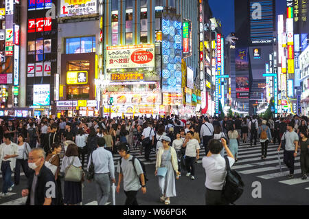 Menschen, die die Straße in Shinjuku, Godzilla Straße, Tokio, Japan, nachts überqueren. Stockfoto