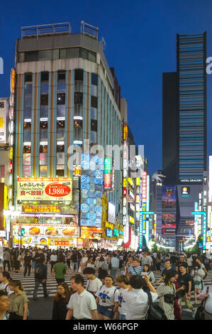 Menschen, die die Straße in Shinjuku, Godzilla Straße, Tokio, Japan, nachts überqueren. Stockfoto