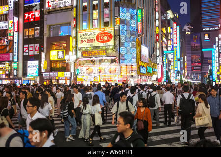 Menschen, die die Straße in Shinjuku, Godzilla Straße, Tokio, Japan, nachts überqueren. Stockfoto