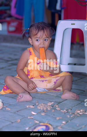 Junge balinesische Mädchen essen ein Eis am Stiel Kuta Bali Indonesien Stockfoto