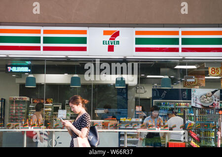 ---- Ein Fußgänger geht Vergangenheit ein kleiner 7-Eleven-Supermarkt in Guangzhou City, die südchinesische Provinz Guangdong, 11. Juni 2018. Internationale konventionelle Stockfoto