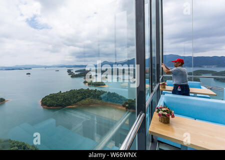 Touristen genießen die Landschaft auf der 99 Meter hohen gläsernen Turm an der Lushan Xihai scenic Spot in Conghua City, der ostchinesischen Provinz Jiangxi, 8 Ju Stockfoto