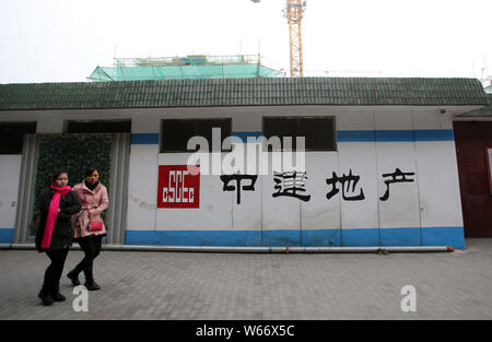 ---- Fußgänger vorbei an einem Namensschild von Cscec (China State Construction Engineering Corporation) in Shanghai, China, 22. Januar 2015. Greenwich Stockfoto