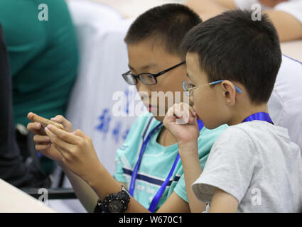 ---- Kurzsichtige Kinder tragen Brillen Videospiele auf ein Smartphone in Zhengzhou City spielen, der Central China Provinz Henan, 17. Juli 2018. Ein Stockfoto