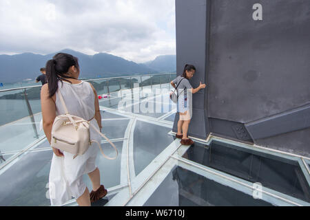 Touristen genießen die Landschaft auf der 99 Meter hohen gläsernen Turm an der Lushan Xihai scenic Spot in Conghua City, der ostchinesischen Provinz Jiangxi, 8 Ju Stockfoto