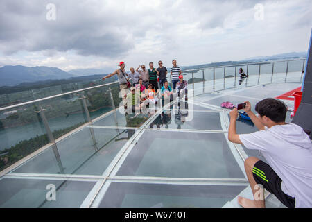 Touristen genießen die Landschaft auf der 99 Meter hohen gläsernen Turm an der Lushan Xihai scenic Spot in Conghua City, der ostchinesischen Provinz Jiangxi, 8 Ju Stockfoto
