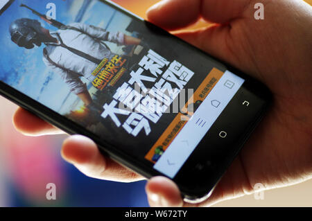 ---- Eine Chinesische mobile Game Player spielt's Tencent multiplayer Online Battle Royale's Spiel PlayerUnknown Schlachtfelder, auf sein Smartphone in Ji'nan Stockfoto