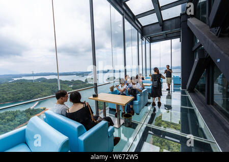 Touristen genießen die Landschaft auf der 99 Meter hohen gläsernen Turm an der Lushan Xihai scenic Spot in Conghua City, der ostchinesischen Provinz Jiangxi, 8 Ju Stockfoto