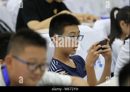 ---- Kurzsichtige Kinder tragen Brillen Videospiele auf Smartphones in Zhengzhou City spielen, der Central China Provinz Henan, 17. Juli 2018. Ein Stockfoto