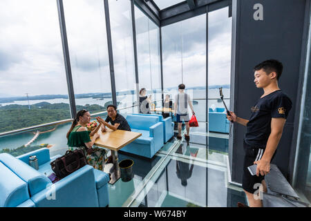 Touristen genießen die Landschaft auf der 99 Meter hohen gläsernen Turm an der Lushan Xihai scenic Spot in Conghua City, der ostchinesischen Provinz Jiangxi, 8 Ju Stockfoto