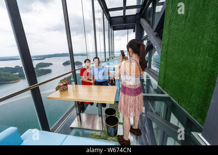 Touristen genießen die Landschaft auf der 99 Meter hohen gläsernen Turm an der Lushan Xihai scenic Spot in Conghua City, der ostchinesischen Provinz Jiangxi, 8 Ju Stockfoto