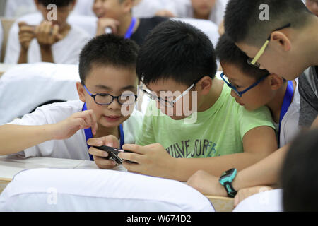 ---- Kurzsichtige Kinder tragen Brillen Videospiele auf ein Smartphone in Zhengzhou City spielen, der Central China Provinz Henan, 17. Juli 2018. Ein Stockfoto