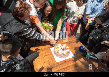 Zhong Fengmin, ihre amerikanischen und chinesischen Familie, freiwillige Helfer und Polizisten teilen sich einen Kuchen in Guangzhou City, die südchinesische Provinz Guangdong, 3 Jun Stockfoto