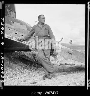 Leutnant Paul Dorsey ein Marine Corps Fotograf an Comndr. Edward Steichen's Naval Aviation fotografischen steht neben einer ruinierten Jap Ebene auf Guam. Stockfoto