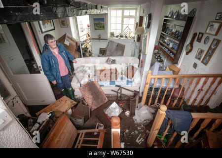 Rowena Hutchinson, Inhaber von The Red Lion Inn in Langthwaite, North Yorkshire, steht im Wohnzimmer nach Hause und Pub waren durch Hochwasser verwüstet, nachdem Teile der Region hatte bis zu 82,2 mm Regen in 24 Stunden am Dienstag. Stockfoto