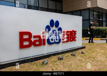 ---- Ein Fußgänger geht vorbei an einer Tafel von Baidu auf ein Bürogebäude in Shanghai, China, 26. Juni 2018. Baidu und BMW haben eine Vereinbarung unterzeichnet. Stockfoto