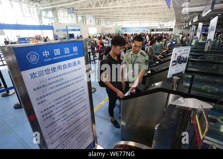 ------ Chinesische Bürger, die im Ausland für Einwanderung Inspektion Warteschlange, die von den Offizieren des Präsidiums der Ausreise und Einreise Administration an der Th zu reisen Stockfoto