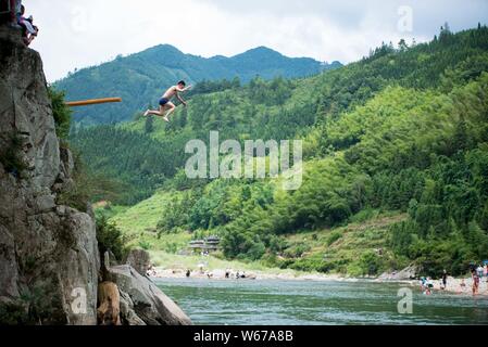 Ein Mann der Zhuang, die ethnischen Minderheiten angehören, springt ins Wasser Das Wasser springen Tiaoshui Festival (Festival) in Congjiang County, qiandongnan Miao zu feiern. Stockfoto