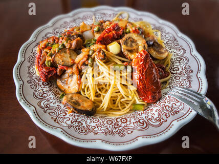 Eine mediterrane Pasta essen in einem dekorierten Teller Stockfoto