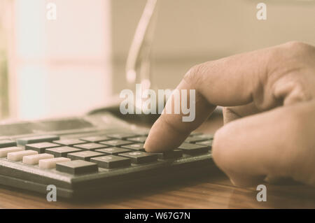 Nahaufnahme des Drücken Sie die rechte Taste. Taschenrechner mit Finger. Finger drücken die Tasten des Rechners. Ein Geschäftsmann Eingabe von Hand berechnen. Stockfoto