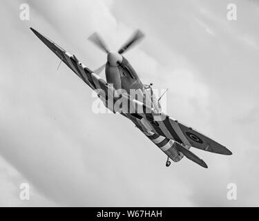 Steve Brooks, die die Stadt Exeter Spitfire. Bild ist die Spitfire klettern und Banking. Pilot deutlich sichtbar. Stockfoto