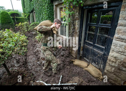 Ein Soldat von 2 Yorks Stapel Sandsäcke in Grinton, North Yorkshire, nachdem Teile der Region hatte bis zu 82,2 mm Regen in 24 Stunden am Dienstag. Stockfoto