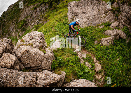MORZINE, Frankreich. Ein Mountainbiker, eine schmale alpine Trail mit Geröll und Felsen im Hintergrund. Stockfoto