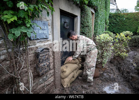 Ein Soldat von 2 Yorks Stapel Sandsäcke in Grinton, North Yorkshire, nachdem Teile der Region hatte bis zu 82,2 mm Regen in 24 Stunden am Dienstag. Stockfoto