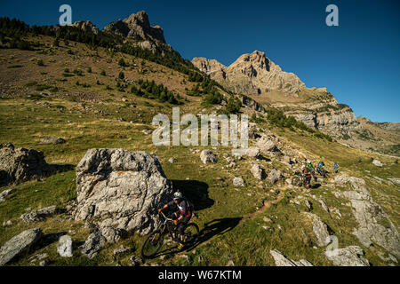Los Realejos, HUESCA, SPANIEN. Eine Gruppe von Mountainbikern, einer schmalen felsigen Trail mit dramatischen Gipfel und blauen Himmel hinter sich. Stockfoto