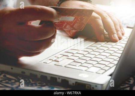 Männliche Hand eine Kreditkarte bei einer Internet Payment Transaction. Konzept des e-Commerce und Online Shopping. Stockfoto