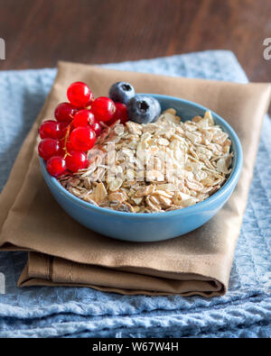 Haferflocken in eine blaue Schale mit Beeren Stockfoto