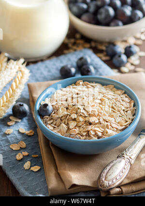 Müsli in eine Schüssel geben, Milch, Blaubeeren - gesundes Frühstück Stockfoto