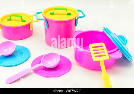 Satz von Spielzeug für Kinder bunte Gerichte auf weißem Hintergrund. Kind Spielzeug Utensil für Mädchen Spiel Stockfoto