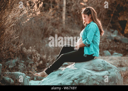 Schwangere Frau im Wald Stockfoto