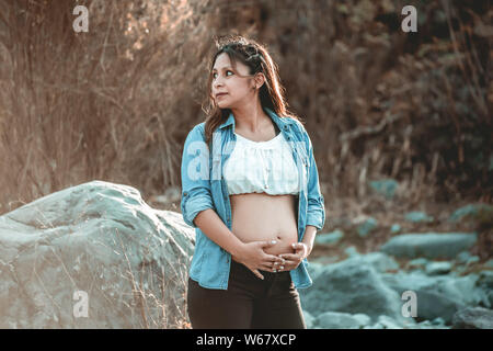 Schwangere Frau im Wald Stockfoto