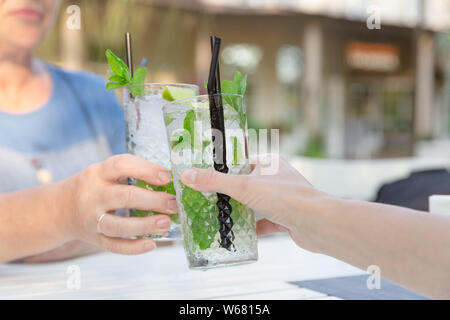 Zwei Frauen trinken mojito Cocktail an der Bar im Freien Restaurant. Sommerfest spaß Festival Stockfoto