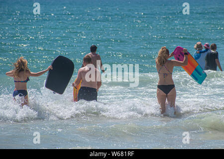 Daytona Beach Florida. Juli 07, 2019 Familie mit Surfbrett Wellen genießen. Stockfoto