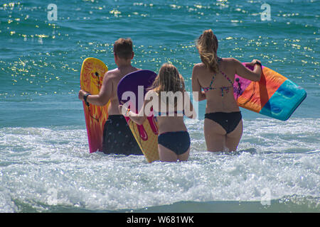 Daytona Beach Florida. Juli 07, 2019 Familie mit Surfbrett Wellen genießen. Stockfoto